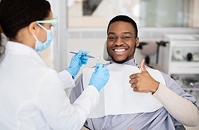 Happy dental patient giving thumbs-up gesture