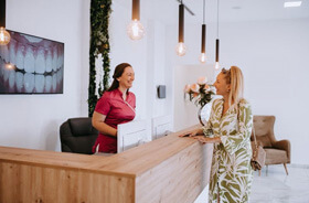 patient talking with dental office front desk team member