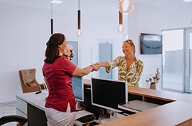 Patient shaking hands with dental receptionist