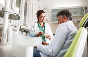 Mature dental patient talking to dentist