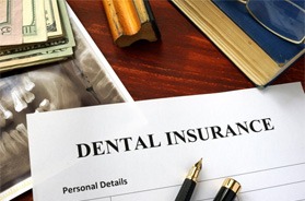 Dental insurance form next to X-ray and money