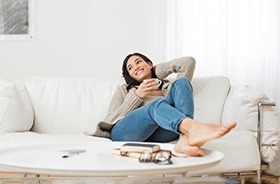 Woman relaxing on sofa after dental appointment