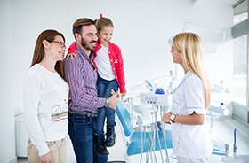 Happy family interacting with dental team member