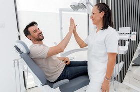 Happy patient high-fiving dental team member