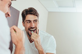 Handsome man brushing his teeth